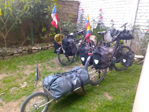 a group of bikes parked in the grass with flags at Hostal Casa del Montañista in Huaraz