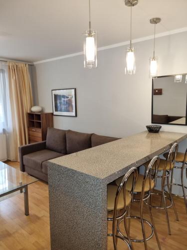 斯維諾烏伊希切的住宿－Apartament Cafe Del Mar，厨房以及带沙发和桌子的客厅。