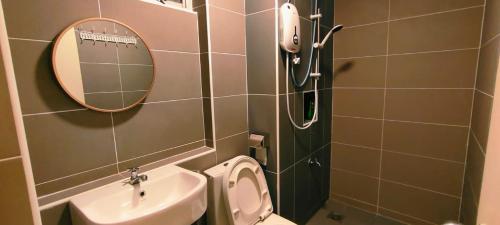 a bathroom with a sink and a toilet and a mirror at Kulai d putra suites beside ioiMall near JPO and Airport in Kulai
