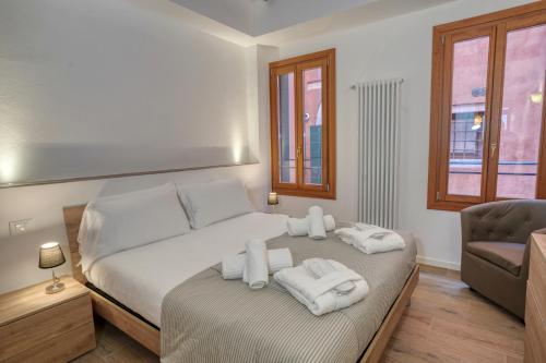 een slaapkamer met een bed met handdoeken erop bij Ecco Suites Apartments in Venetië