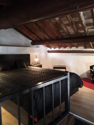 une chambre avec un lit noir dans une pièce dans l'établissement Gîte Coquelicot, à Gargas