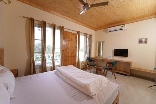 a bedroom with a bed and a desk and a television at Hotel Sarai Bharatgarh in Chandīgarh