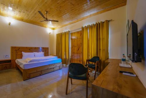 a bedroom with a bed and a chair and a tv at Hotel Sarai Bharatgarh in Chandīgarh