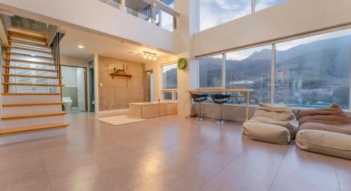 a large living room with a couch and large windows at Hinokki Haesuzzim Resort in Geoje 