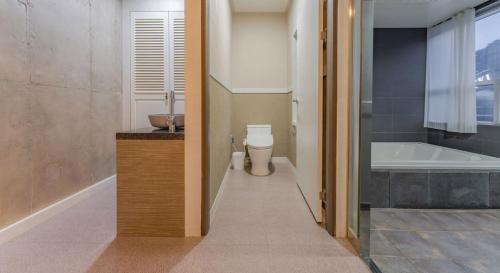 a bathroom with a tub and a toilet and a sink at Hinokki Haesuzzim Resort in Geoje 