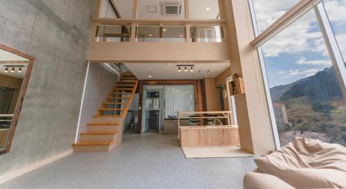 a room with a staircase and a large window at Hinokki Haesuzzim Resort in Geoje 