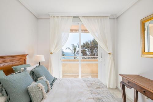 ein Schlafzimmer mit einem Bett und einem großen Fenster in der Unterkunft Apartamento familiar vistas al mar by Rent Me in Estepona