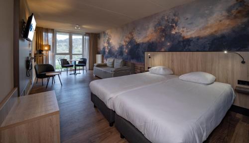 ein Schlafzimmer mit einem großen Bett und ein Wohnzimmer in der Unterkunft Fletcher Hotel Restaurant Zeeduin in Wijk aan Zee