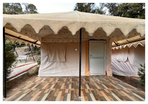 a large tent with a door on a wooden floor at The Cocoon Camps & nature Resorts in Nainital