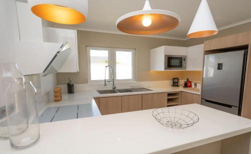 a kitchen with a white counter and a refrigerator at VILLA LILOU, Splendide villa au centre de Grand Baie in Grand Baie