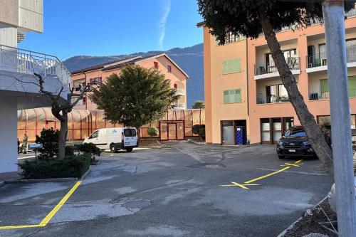 a parking lot with cars parked in front of a building at Domaine des Bains de Saillon in Saillon