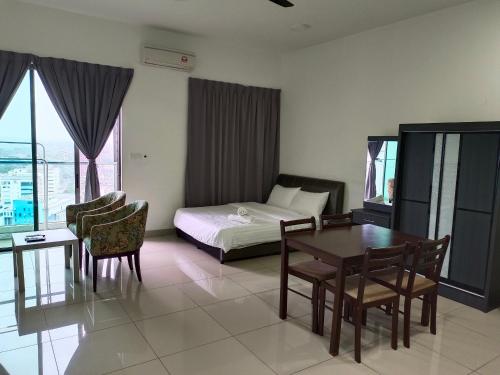 ein Hotelzimmer mit einem Bett, einem Tisch und Stühlen in der Unterkunft Peace home 23 in Cyberjaya