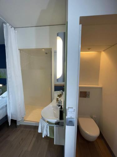 a bathroom with a sink and a toilet and a shower at ibis budget Belfast City Centre in Belfast