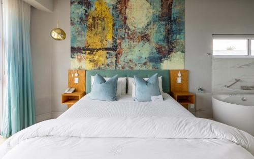 a bedroom with a large bed and a bath tub at Hermanus Boutique Guest House in Hermanus