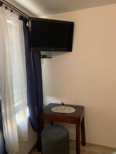 a room with a table and a tv on the wall at B&B Sandrina in Bilje