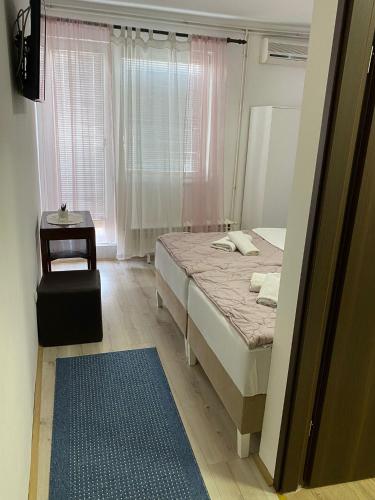 a bedroom with a bed and a table and a window at B&B Sandrina in Bilje