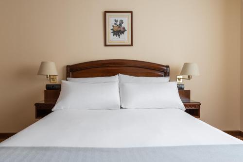 a bed with white sheets and pillows in a bedroom at Exe Astur Plaza in Astorga