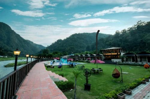 a walkway next to a river with a resort at DLS MJ River Resort, Rishikesh in Shivpuri