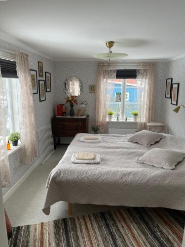 Kristdala的住宿－Carina & Peters Place，一间卧室设有一张大床和两个窗户。