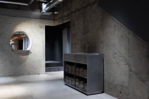 a bathroom with a shelf of wine bottles at KUMU Kanazawa by THE SHARE HOTELS in Kanazawa