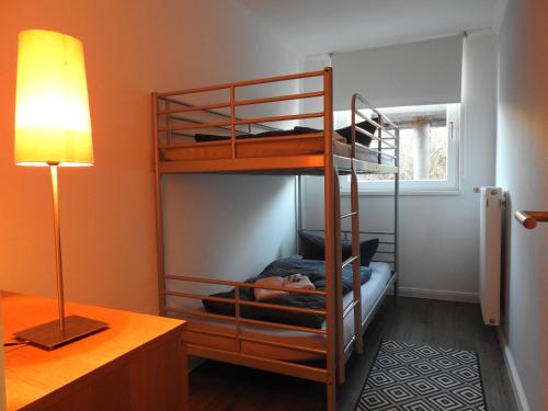 Cette chambre comprend deux lits superposés et une lampe. dans l'établissement Haus ohne Namen Juist, à Juist