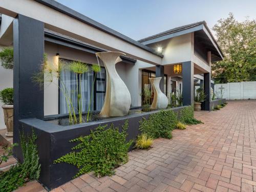 a house with three vases on the side of it at Magnolia Guesthouse in Alberton