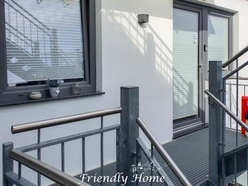 a balcony with a black railing and a window at Friendly Home - Doppelappartement "Purple" Köln Bonn Phantasialand in Brenig