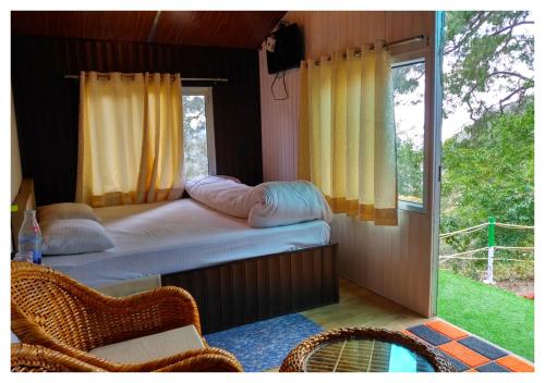 - une chambre avec un lit et une fenêtre avec une piscine dans l'établissement The Cocoon Camps & nature Resorts, à Nainital
