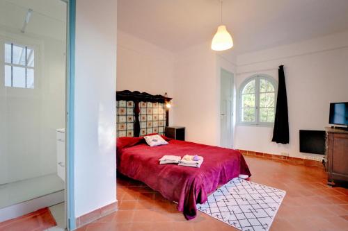 1 dormitorio con cama roja y ventana en Villa Bagaud, en Rayol-Canadel-sur-Mer