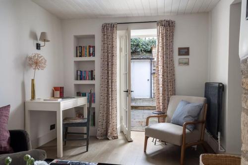 a living room with a desk and a window at Whitsun Cottage in Stow on the Wold