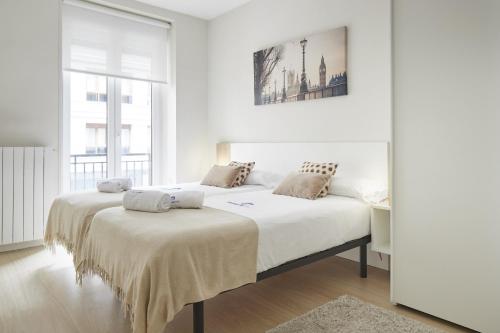 サン・セバスティアンにあるIzpide - Basque Stayの白いベッドルーム(大型ベッド1台、デスク付)