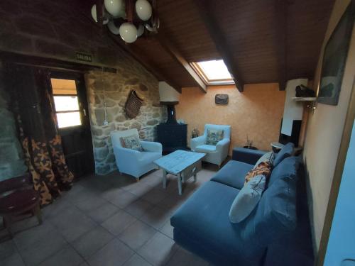 een woonkamer met een blauwe bank en stoelen bij La Era De Sanabria in Villarino de Sanabria