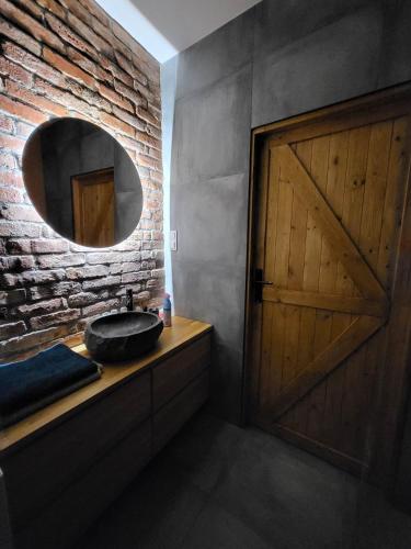 ein Badezimmer mit einer Holztür und einem Spiegel in der Unterkunft Tatarska Sen Apartamenty in Przemyśl
