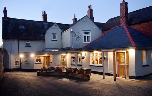 a couple of buildings with lights on them at The Wallace Steakhouse with Rooms in Usk