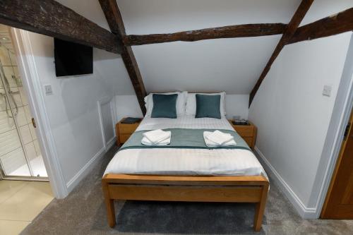 a bedroom with a bed with blue pillows at The Wallace Steakhouse with Rooms in Usk
