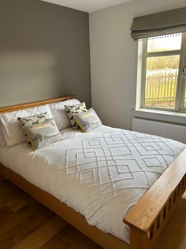 a bedroom with a large bed with a wooden headboard at The Oaks, Luxury 2 bedroom cottage in a peaceful location in Haughley