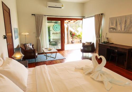 a bedroom with a bed with a swan on it at Seaflower Bungalows in Srithanu