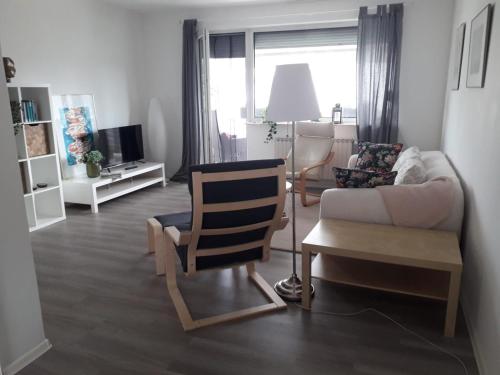 uma sala de estar com um sofá e uma cadeira em Moderne helle Ferienwohnung em Remagen