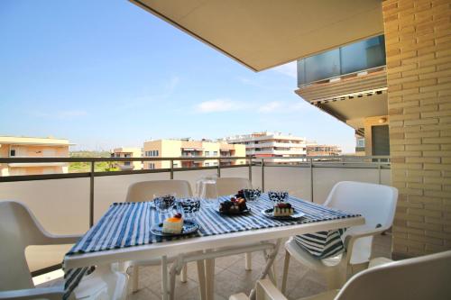 a table and chairs on a balcony with a view of a city at Mediterranean Way - Maldivas in La Pineda
