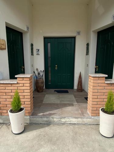 duas portas verdes num edifício com vasos de plantas em Casa Morea em Cignone