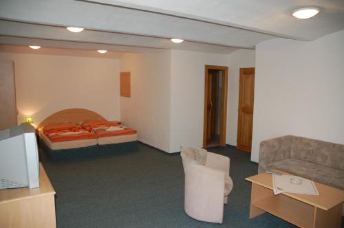 a hotel room with a bed and a couch at Penzion U Vlka in České Budějovice