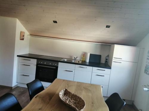 a kitchen with a wooden table and a sink at Ferienwohnung Saaleblick in Schwarzenbach an der Saale