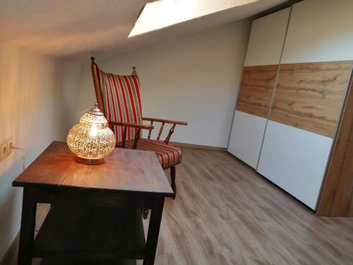a room with a chair and a table with a lamp at Ferienwohnung Saaleblick in Schwarzenbach an der Saale