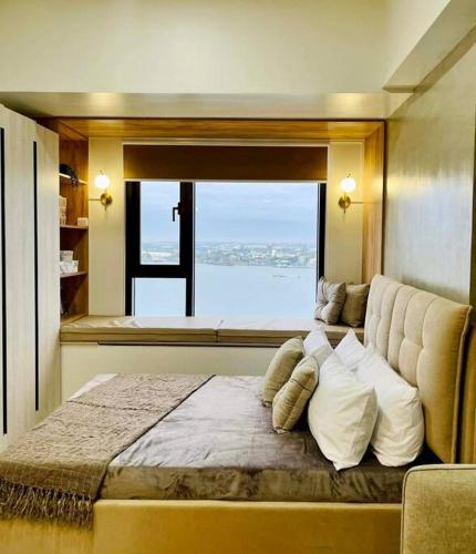 a bedroom with a large bed with a large window at Stunning Bayview Studio in Cebu in Guizo