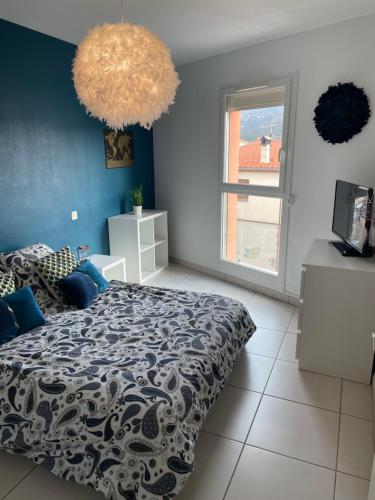 1 dormitorio con cama y pared azul en Appartement T3 climatisé,balcon en Le Boulou
