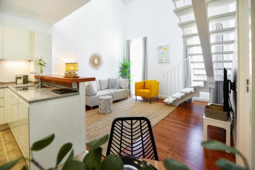 a kitchen and a living room with a couch at Querido Algarve Apartment in Faro