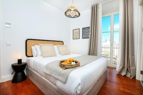 a bedroom with a bed with a basket of fruit on it at Querido Algarve Apartment in Faro