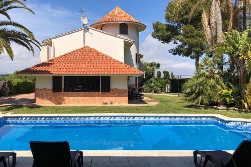 a house with a swimming pool in front of a church at Mediterranean Way - Villa Singular in Salou
