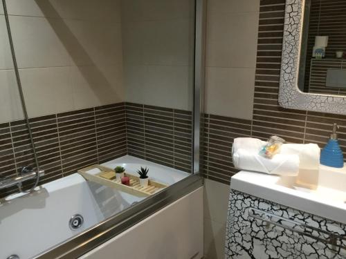 a bathroom with a tub and a sink at Gran piso alto LuzDiseño centrico con garaje in León