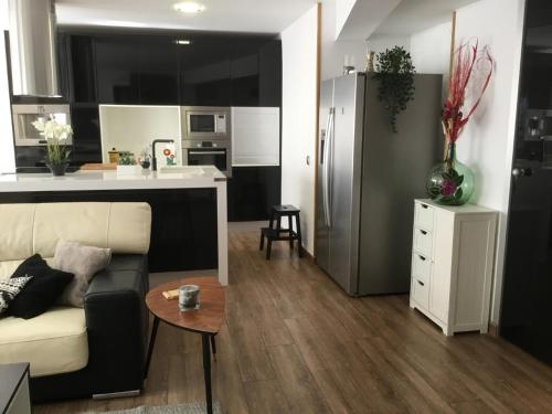 a living room with a couch and a kitchen at Gran piso alto LuzDiseño centrico con garaje in León